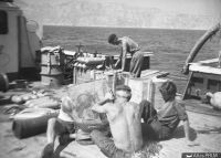 Chantier à bord de la Calypso. Remplissage des bouteilles de scaphandre et confection du panier-filtreur (d'après Benoit 1961, p. 20)