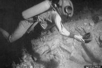 Vue sous-marine d'un scaphandrier ramassant les céramiques (© Archives Drassm)