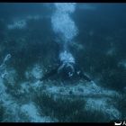 Vue sous-marine d'un plongeur avec l'ancre en fer. Fouille de C. Dovis (© D. Metzger/DRASSM)