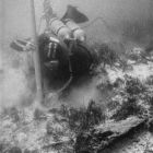 Plongeur dégageant un fragment de la coque au moyen de la suceuse (© Archives Drassm)