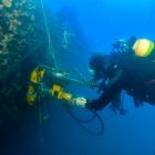 Plongeur autonome travaillant au niveau de la carotteuse installée sur la partie tribord de l'Alice Robert (© Frédéric Osada, Images Explorations)