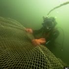 Déroulé d'un filet pour retenir les bermes créées par la fouille. (Cliché T. Seguin © O'Can-Ipso Facto, Mdaa/CG13)